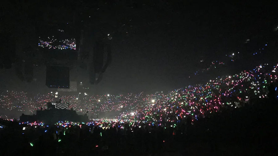 Grande salle sombre aux bracelets LED multicolores dans les gradins